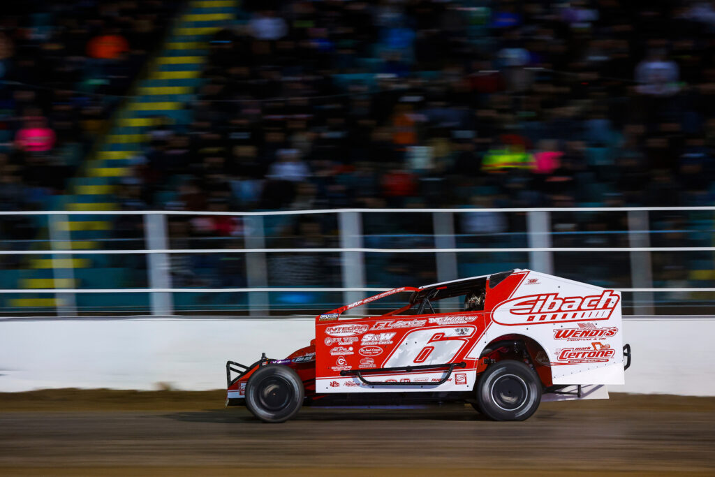 Mat Williamson racing his DIRTcar 358 Modified race car around Oswego Speedway during the Salute to the Troops 150 at Super DIRT Week 52